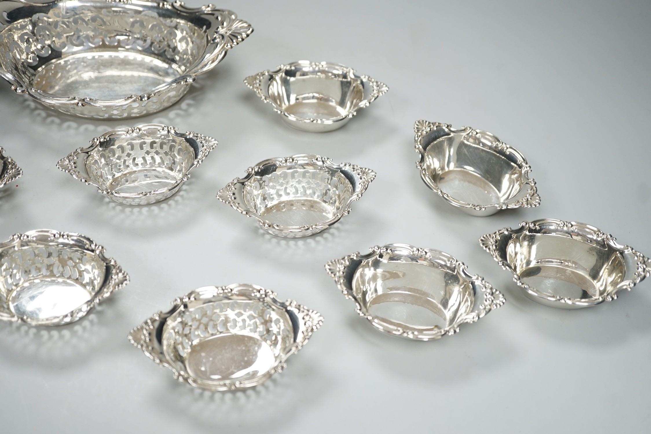 A set of ten Canadian Birks pierced sterling nut dishes, 97mm and a similar larger dish, 20.8cm, 11oz.